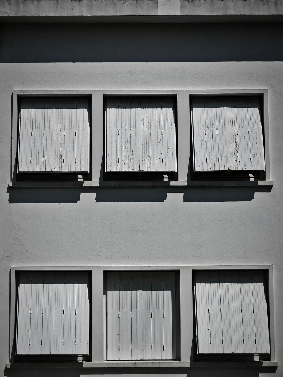 Les volets roulants électriques délaissés : le retour en force du système en bois traditionnel sur nos façades